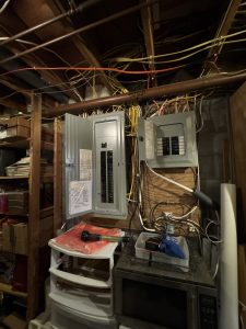 Electrical panel wiring upgrade showing messy wires and cable